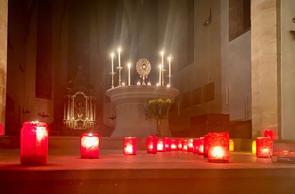 Blick auf den Altar mit dem Allerheiligsten und davor sind viele Kerzen